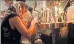  ??  ?? LIGHT OF HOPE: A woman and her children light candles during a mass at the Saint Nicolas Orthodox church in Nice.