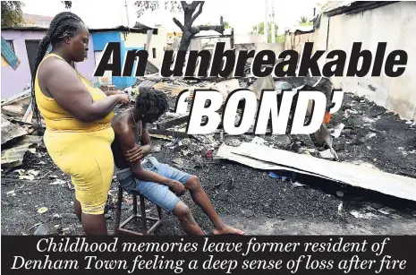  ?? FILE ?? Kaysia Williams (left) doing the hair of Delano Wright, in the remains of the premises destroyed by fire at 68 and 70 Bond Street in Denham Town.