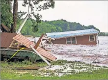  ?? LANDSBERGE­R/THE OKLAHOMAN] [CHRIS ?? Floodwater­s from the Cimarron River wash away a home in the Twin Lakes community, near Cimarron City, on Wednesday.