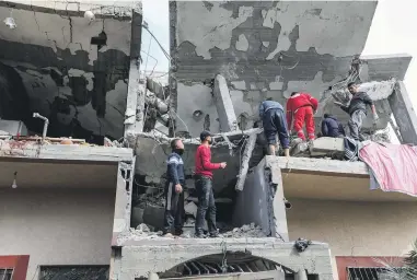  ?? GETTY IMAGES ?? People inspect damage and recover items from their homes following Israeli air strikes in Rafah, Gaza. Israeli officials will head to Washington to discuss a promised military operation in Rafah, which is currently home to an estimated 1 million Palestinia­n refugees.