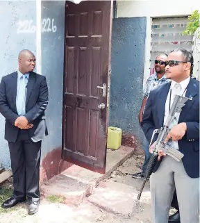  ??  ?? Security personnel wait outside while Prime Minister Andrew Holness and aides visited the mother of Micholle Moulton last week.