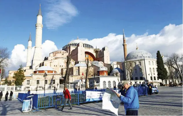  ?? Reuters ?? ↑ A tourist near the Byzantine-era monument of Hagia Sophia, at Sultanahme­t square in Istanbul, Turkey.