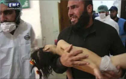  ?? THE ASSOCIATED PRESS ?? A man carries a child into a makeshift hospital following a suspected chemical attack in the town of Khan Sheikhoun, northern Idlib province, Syria. It was the third claim of a chemical attack in just over a week in Syria.