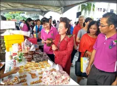  ??  ?? Chai purchases food at one of the stalls in support of the sale.