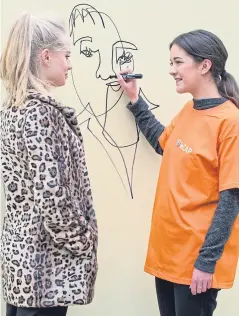  ?? Picture: Angus Findlay. ?? Artist Allana Hardie sketches a ‘blind’ portrait of ReCap producer Poppy Jarratt in Skinnergat­e Vennel, Perth.
