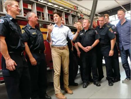  ?? GARY NYLANDER/Special to The Herald ?? Prime Minister Justin Trudeau meets with Kelowna firefighte­rs during a stop at the main fire hall on Enterprise Way Tuesday afternoon. Trudeau and the rest of the federal Liberal caucus are in Kelowna for a two-day retreat prior to the fall sitting of...