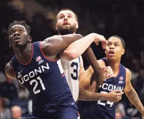  ?? Brady Klain / Getty Images ?? UConn’s Adama Sanogo (21) and Butler’s Byrce Golden jockey for position under the basket on Thursday in Indianapol­is.