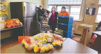  ?? ?? Bonnie Wendt, right, received food and a fridge at Vancouver's Killarney Secondary. The fridge was provided by David Mccann, left, and the food by Lisa Martella, centre, of A Loving Spoonful Meals Society.