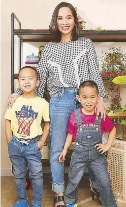  ??  ?? Christine Dychiao, social media personalit­y, in Esprit checkered bell-sleeved blouse and jeans; Tepper in OshKosh denim overalls with red jersey tee; and Xavi in OshKosh yellow jersey T-shirt