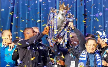  ??  ?? Vichai (second right), Ranieri (third right) and Leicester City’s English defender Wes Morgan (second left) hold up the Premier league trophy to fans as the Leicester City team celebrate in Victoria Park, after taking part in an open-top bus parade through Leicester, to celebrate winning the Premier League title in this May 16, 2016 file photo. — AFP photo