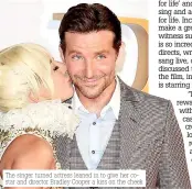  ??  ?? The singer turned actress leaned in to give her costar and director Bradley Cooper a kiss on the cheek