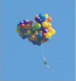  ?? Tom Warne / Handout ?? Dan Boria flies in his lawn chair and helium balloons Sunday for an attempted drop into Stampede Park. The amateur aviator crashed and has been charged by police.
