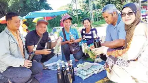  ??  ?? HASIN lebah. (kiri) bersama sebahagian penjual serta pelanggan madu kelulut dan madu