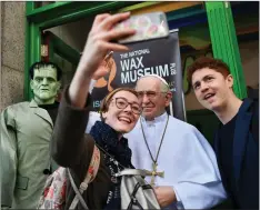  ??  ?? Visitors take a selfie photograph as they pose with a wax model of Pope Francis outside The National Wax Museum in Dublin on, the eve of Pope Francis’ visit to Ireland. — AFP photo
