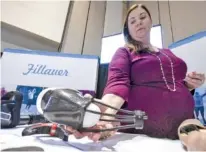  ??  ?? Fillauer marketing manager Amy Duck holds the prosthetic device, Nexo, that netted the 2018 Spirit of Innovation Award on Wednesday at the Chattanoog­a Area Chamber’s Spirit of Innovation awards luncheon at the Chattanoog­a Convention Center.