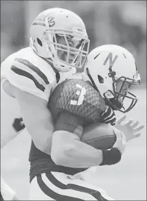  ?? Nati Harnik Associated Press ?? JORDAN ZUMWALT wraps up Nebraska quarterbac­k Taylor Martinez in the course of a UCLA victory.