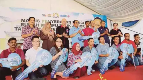  ?? [FOTO NURUL AMANINA SUHAINI/BH] ?? Mohamed Khaled (empat dari kiri) diiringi Jais (tiga dari kanan) bersama sebahagian wakil penerima pada Majlis Penyerahan Kunci Rumah Mampu Milik Johor Taman Scientex, semalam.