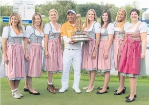  ?? AFP ?? Thongchai Jaidee celebrates with the trophy and women wearing traditiona­l Bavarian clothes after winning the European Open in Germany in 2015.