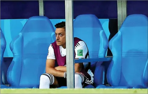  ??  ?? Alone with his thoughts: Mesut Ozil cut a lonely figure in the Germany dug-out as his team-mates took on Sweden on Saturday