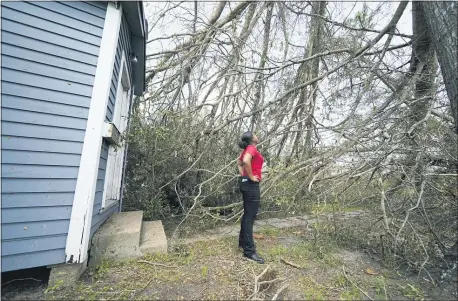  ?? GERALD HERBERT — THE ASSOCIATED PRESS ?? Layla Winbush surveys damage at her home Sunday in Lake Charles, La., by Hurricane Laura. The family business was also damaged.