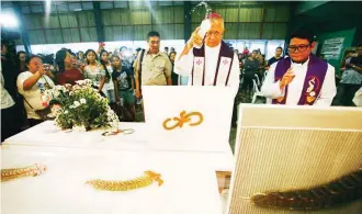  ??  ?? BLESSING FOR LANDSLIDE VICTIMS – Cebu Archbishop Jose Palma blesses the bodies of the landslide victims in Naga, Cebu. The search continues for the close to 60 people that are still missing in Tinaan, Naga City. (Juan Carlo de Vela)