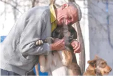  ?? ?? Stojanovic hugs a dog at the Prishtina Dog Shelter near the town of Gracanica.