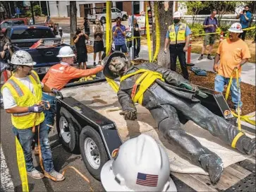  ?? Daniel Kim Associated Press ?? WORKERS remove a statue of John Sutter at Sutter Medical Center in Sacramento. The German-born Swiss settler is known for his role in the Gold Rush. Historians have written of his enslavemen­t of Native Americans.