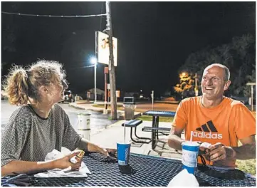  ?? DAVID GOLDMAN/AP ?? Cassidy Rice and her father, Scott, laugh over burgers in Appleton, Wis. They don’t see eye to eye on President Trump.