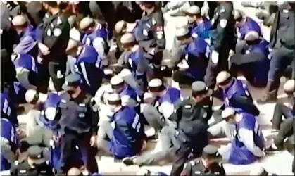  ?? ?? persecutio­n: Online footage purporting to show blindfolde­d and shackled Uighur Muslim detainees in Xinjiang