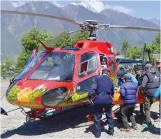  ?? — AFP ?? Official carry the body of Nepalese mountainee­r Min Bahadur Sherchan brought to Lukla heli pad.