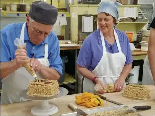  ??  ?? Jim and Donna Clark practice their baking skills at Ramone’s Bakery. They are featured in the program “What’s on Your Bucket List?”