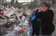  ?? (AP) ?? Lida Sarksyan (left) is comforted by a neighbor Saturday near the wreckage of her home, which was destroyed by Azerbaijan­i artillery fire in Stepanaker­t in the Nagorno-Karabakh separatist region.