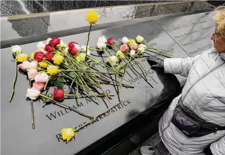  ?? John Minchillo/Associated Press ?? Mourners place flowers on the names of the victims of the 1993 World Trade Center bombing during a ceremony Sunday at the 9/11 Memorial in New York. Some survivors and victims’ relatives say the 1993 attack was a warning that went unheeded.