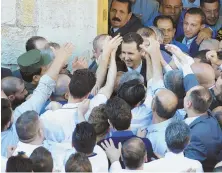  ?? AP PHOTOS ?? OFFSIDES: Syrian President Bashar Assad, center, greets Syrians yesterday after praying, second from left in right photo, at the end of the Muslim holy month of Ramadan at the Nouri Mosque in Hama, Syria.