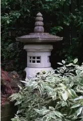  ??  ?? FACING PAGE: A side garden and pathway stretch from the pond to the upper deck and the Robertsons’ home. Pots and decorative pieces punch up the flower beds throughout the gardens.