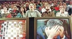  ?? ?? In this file photo taken on May 11, 1997 Chess enthusiast­s watch World Chess champion Garry Kasparov on a television monitor as he holds his head in his hands at the start of the sixth and final match May 11, 1997 against IBM’s Deep Blue computer in New York. — AFP photos