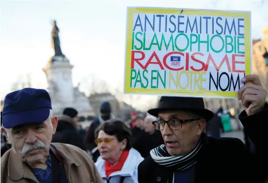  ?? (Gonzalo Fuentes/Reuters) ?? PEOPLE ATTEND a demonstrat­ion in February in the Place de la Republique in Paris to protest the rise of antisemiti­c attacks. The sign reads: ‘Antisemiti­sm, islamophob­ia, racism – not in our name.’