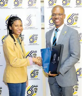  ?? ?? Dr Kevin Brown, president of UTech, Jamaica, presents youngest-ever student, 14 year-old Jada Wright, with tokens of university-branded memorabili­a during his special meeting with the young student and her parent on January 16 at the Papine Campus.
