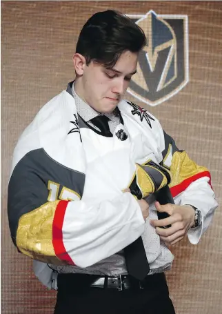  ?? NAM Y. HUH/THE ASSOCIATED PRESS ?? Cody Glass puts on a Vegas Golden Knights jersey after being selected by the team in the NHL draft’s first round on Friday in Chicago. Vegas made three first-round picks on Friday.