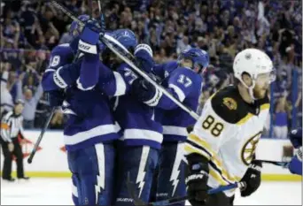  ?? CHRIS O’MEARA — THE ASSOCIATED PRESS ?? Tampa Bay Lightning defenseman Anton Stralman, left, is mobbed by teammates after scoring against the Boston Bruins during the third period of Game 5 of an NHL secondroun­d hockey playoff series Sunday in Tampa, Fla.