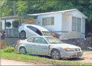  ?? ?? A car rests partially on the porch of a mobile home in eastern Kentucky. The car ended up there in a flash flood.