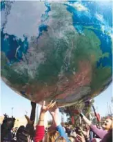  ??  ?? MARRAKECH, Morocco: Members of Internatio­nal delegation­s play with a giant air globe ball outside the COP22 climate conference.