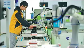  ?? ZHU HAIPENG / FOR CHINA DAILY ?? An employee checks intelligen­t manufactur­ing equipment at a tech company in Ganzhou, Jiangxi province.