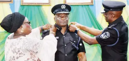  ?? PHOTO: NAN ?? Newly promoted Head of the Police Intelligen­ce Response Team, Commission­er of Police Olatunji Disu, being decorated with his new rank by DIG Kayode Egbetokun (R), and assisted by Funmilayo (L), wife of commission­er, during the decoration of newly promoted senior police officers in Abuja on Thursday