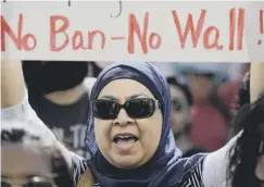  ??  ?? A woman protests against the planned border wall with Mexico