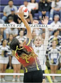  ?? LUIS SÁNCHEZ SATURNO/THE NEW MEXICAN ?? Santa Fe’s Ainsley Reynolds-Smith tries to block a spike from Española’s Cheyanne Martinez during Wednesday’s match at Santa Fe High.