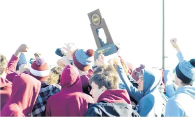  ?? JEFF VORVA/DAILY SOUTHTOWN ?? Lockport High School football players hoist their state championsh­ip trophy during a community celebratio­n Sunday at their stadium.