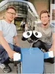  ?? Foto: Anne Wall ?? Roboter swa*lly – hier mit seinen Erbau ern Florian (l.) und Daniel Greiser – ist derzeit aus dem (Nah )Verkehr gezogen. Er muss repariert werden.