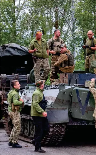  ?? ?? The boys are back in town: Ukrainian forces stand on a captured tank in a liberated area of eastern Ukraine