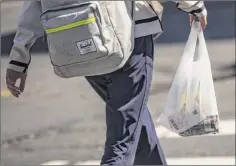  ?? Drew Angerer / Getty Images ?? A shopper leaves a Brooklyn Rite Aid carrying a plastic bag. Gov. Andrew Cuomo has introduced a bill that proposes to ban single-use carryout plastic bags statewide.